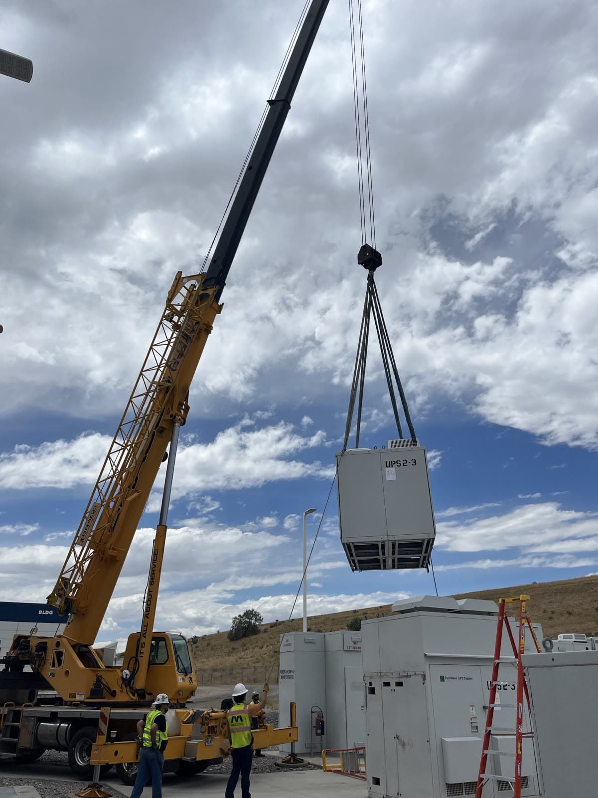 Containerized power system being craned into position on a remote site