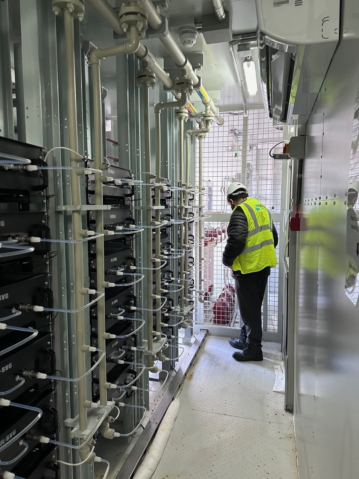 Engineer inspecting a medium-voltage capacitor bank installation